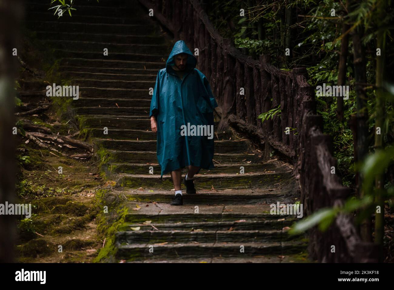Uomo che indossa un impermeabile camminando nella natura Foto Stock