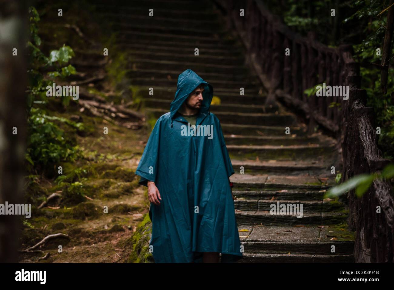 Uomo che indossa un impermeabile camminando nella natura Foto Stock