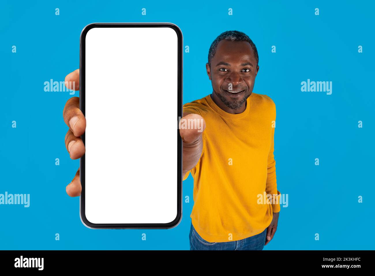 Uomo nero sorridente con telefono cellulare, mockup Foto Stock