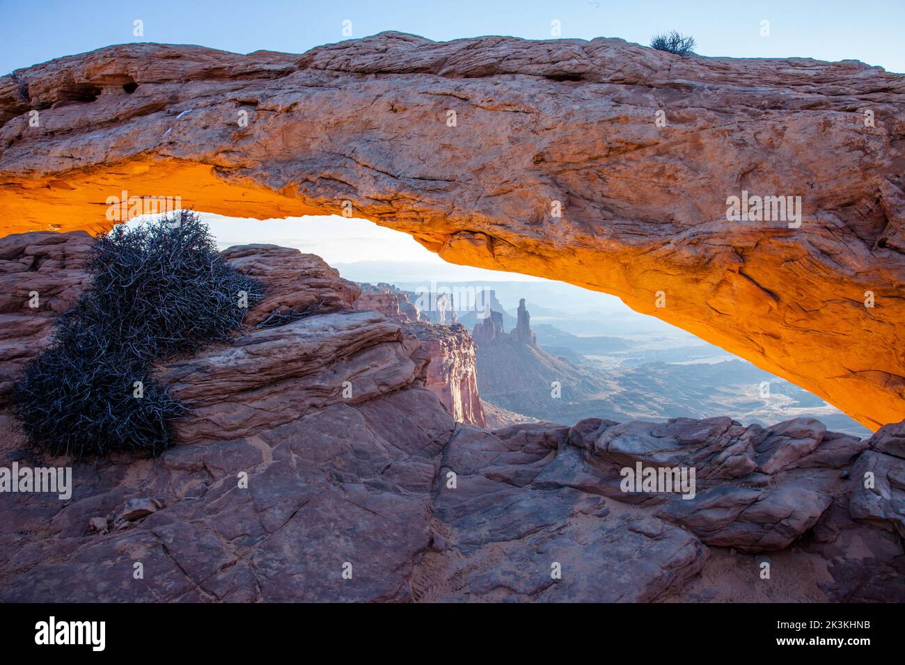 Mesa Arch all'alba con il Washer Woman Arch, la Monster Tower e la Airport Tower. Parco nazionale di Canyonlands, Utah. Foto Stock