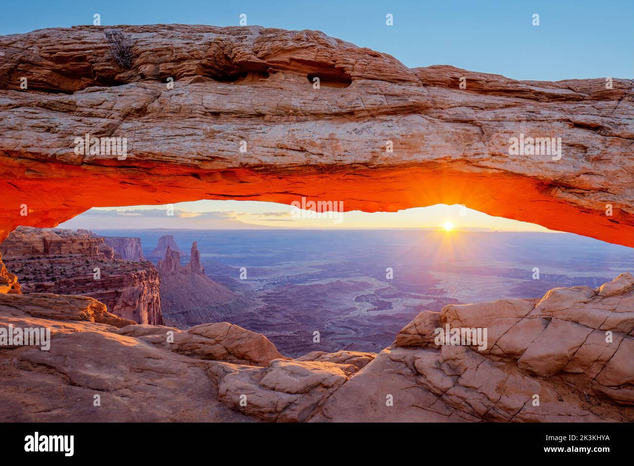 Mesa Arch all'alba con il Washer Woman Arch, la Monster Tower e la Airport Tower. Parco nazionale di Canyonlands, Utah. Foto Stock