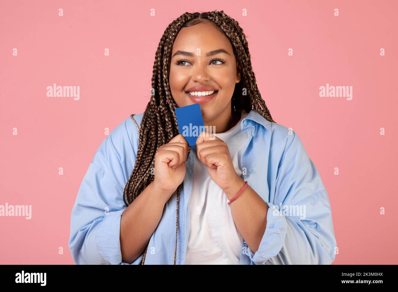 Black Lady Holding carta di credito sognare di Shopping, sfondo rosa Foto Stock