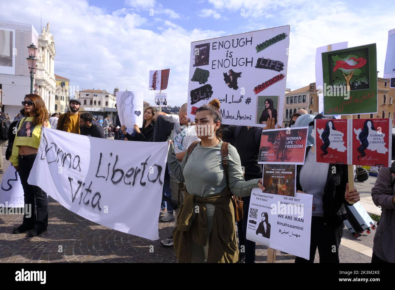 Le ragazze iraniane protestano di fronte alla stazione ferroviaria di Venezia mostrando un cartello con la scritta "Woman Freedom Life" il 27 settembre 2022 a Venezia. Foto Stock