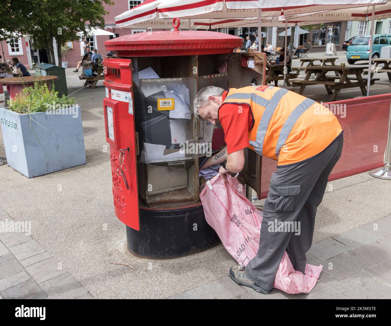 Postman svuotare Royal Mail Postbox, Galles, Regno Unito Foto Stock