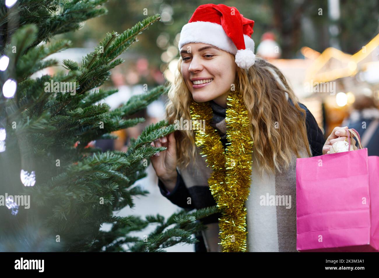 Donna che acquista albero di Natale Foto Stock