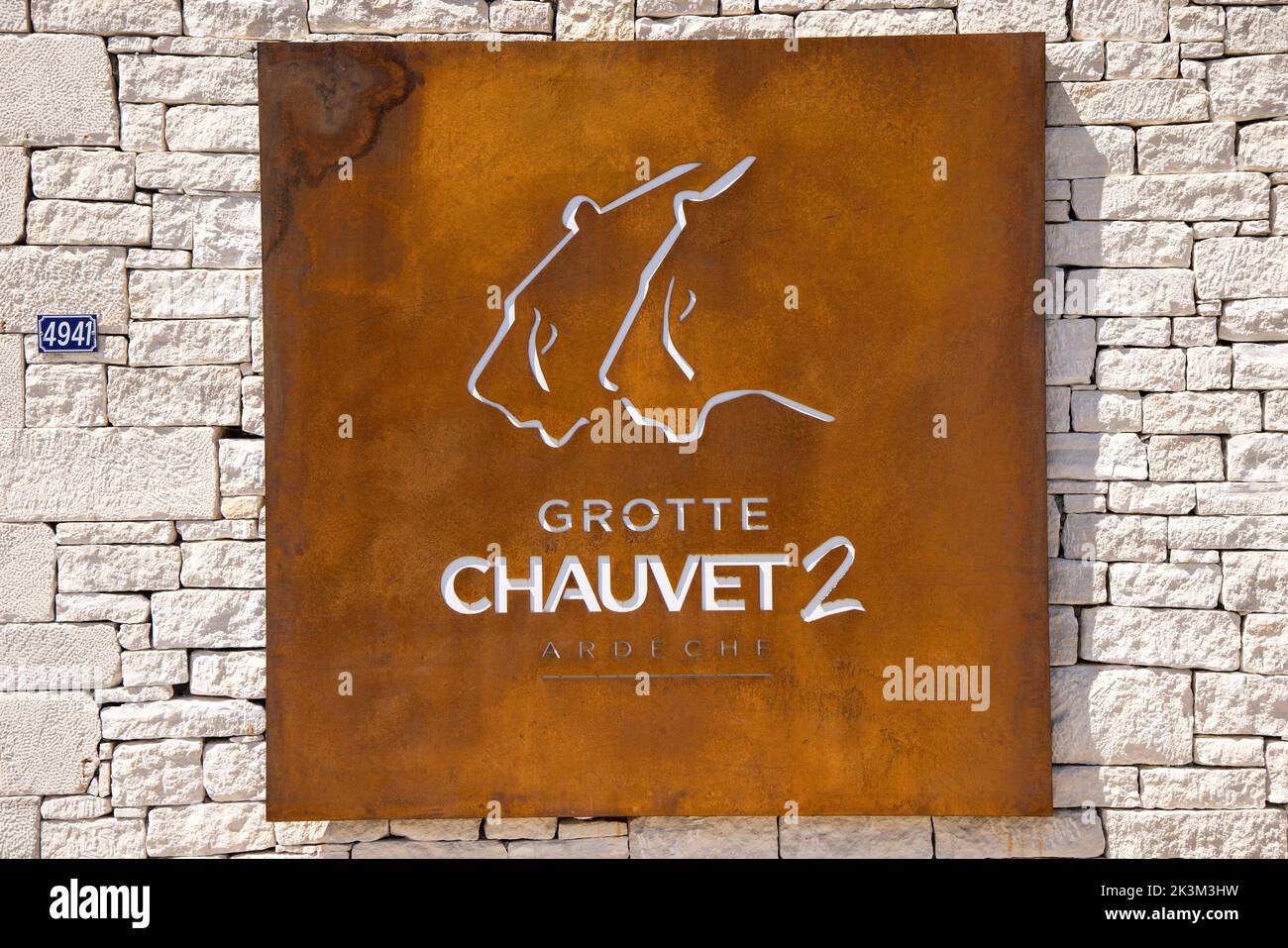 Il segno di metallo all'ingresso della grotta Chauvet 2, la replica della grotta d'arte paleolitica in Ardeche, Francia Foto Stock