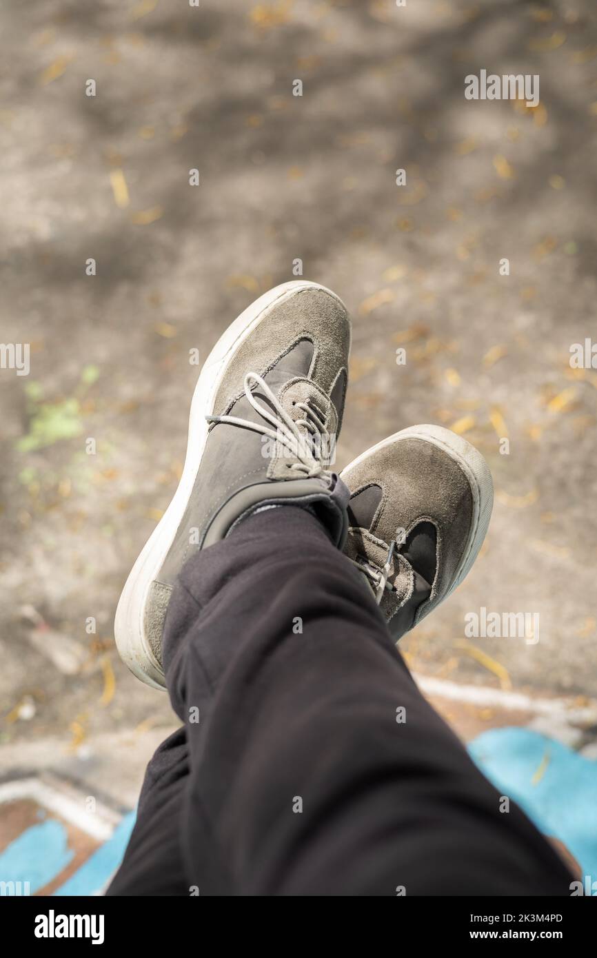 a riposo a croce indossando scarpe sportive grigie con lacci legati, abbigliamento e stile di vita come sfondo Foto Stock