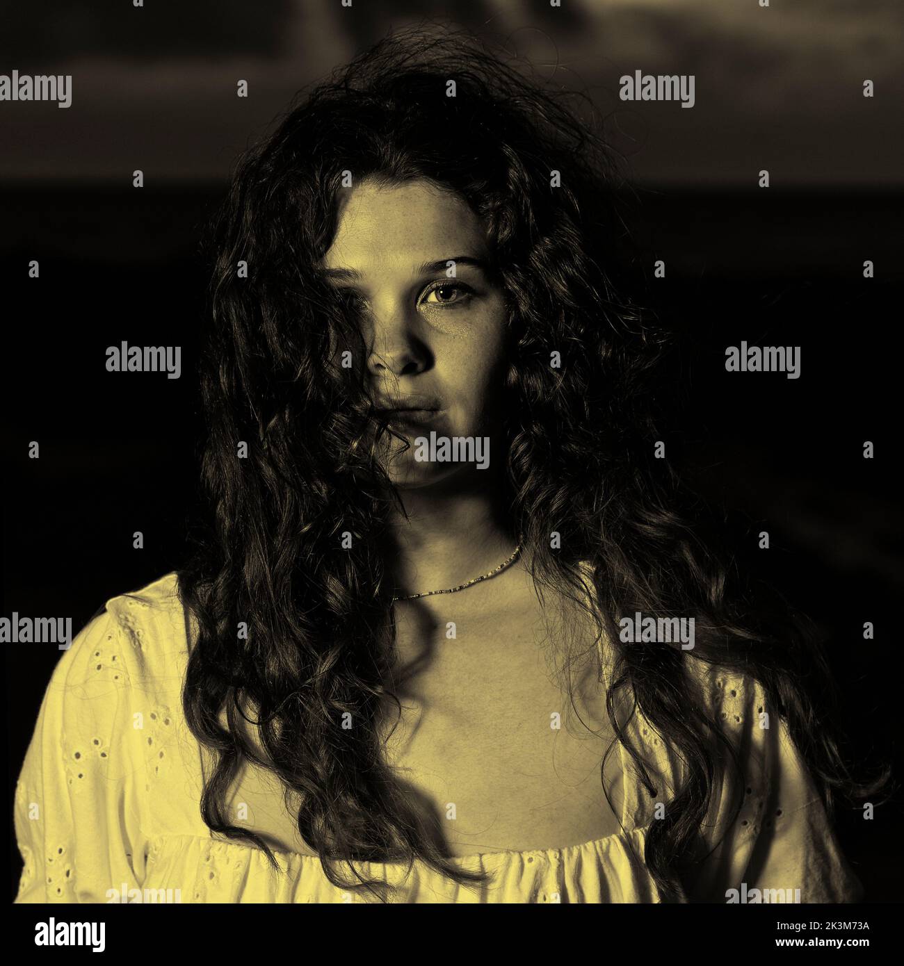 Un misterioso ritratto di una giovane donna di notte con i capelli che soffiano nel vento Foto Stock