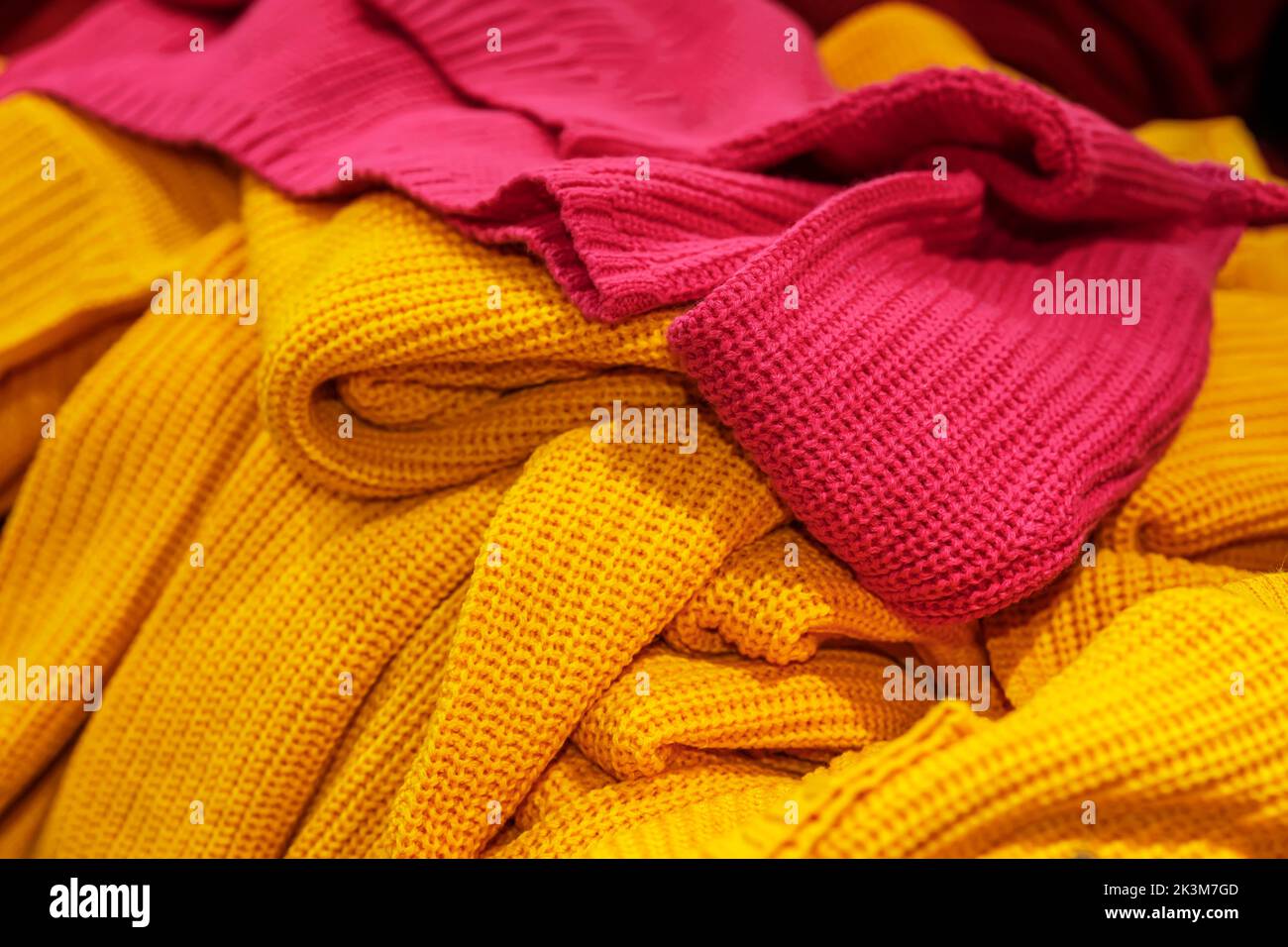 Pullover a maglia in primo piano, giallo e rosso. Shopping autunnale e invernale Foto Stock