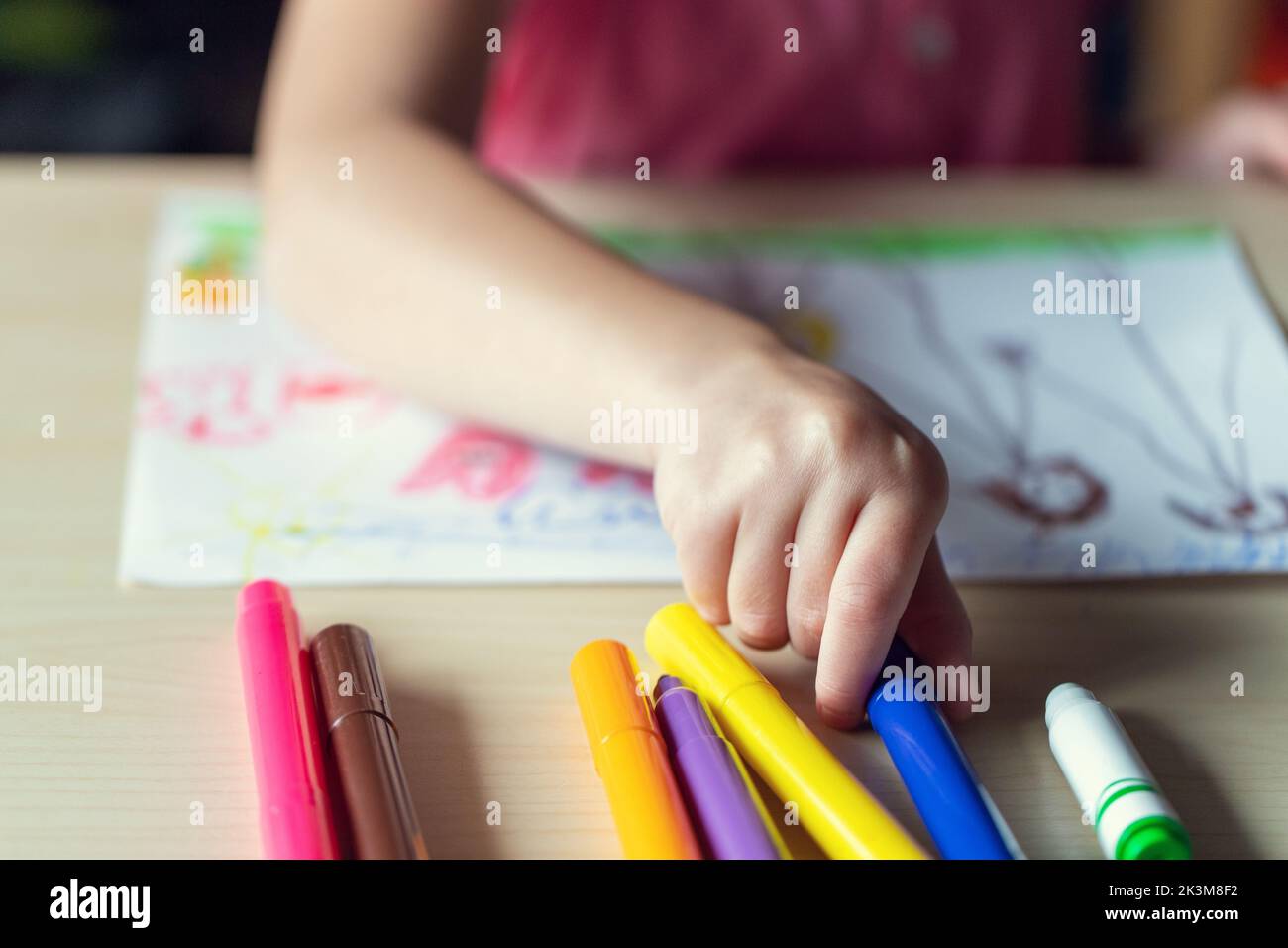 Mano Di Un Bambino Che Disegna Un immagine Con Marcatori Colorati mano-di-un-bambino-che-disegna-un-immagine-con-marcatori-colorati