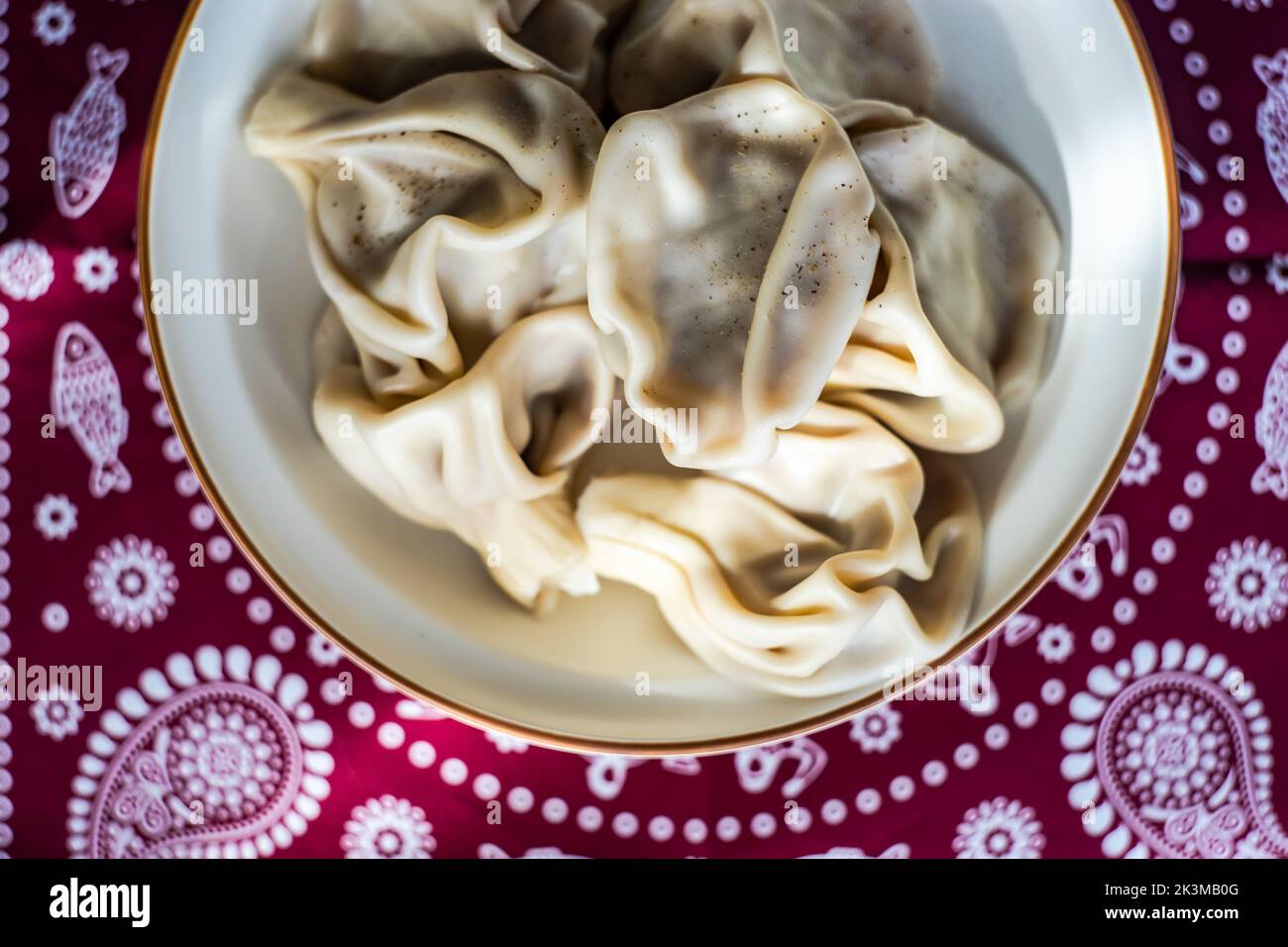I khinkali georgiani sono serviti nella ciotola su una tovaglia Supra tradizionale ricoperta di spezie al pepe nero Foto Stock