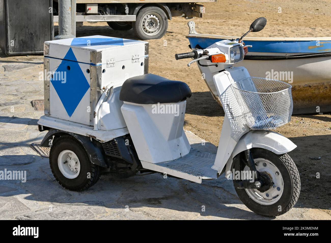 Mykonos, Grecia - Maggio 2022: Piccolo scooter a motore a tre ruote parcheggiato vicino alla spiaggia sull'isola greca di Mykonos Foto Stock