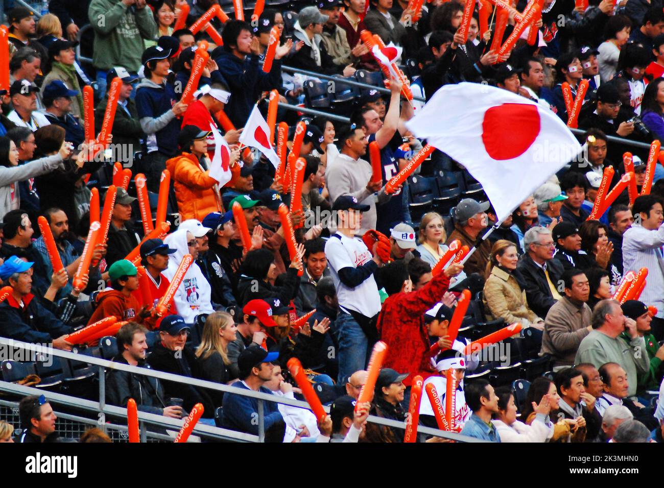 I fan della nazionale giapponese di baseball mostrano il loro orgoglio sventolando la bandiera del Giappone in una partita internazionale Foto Stock