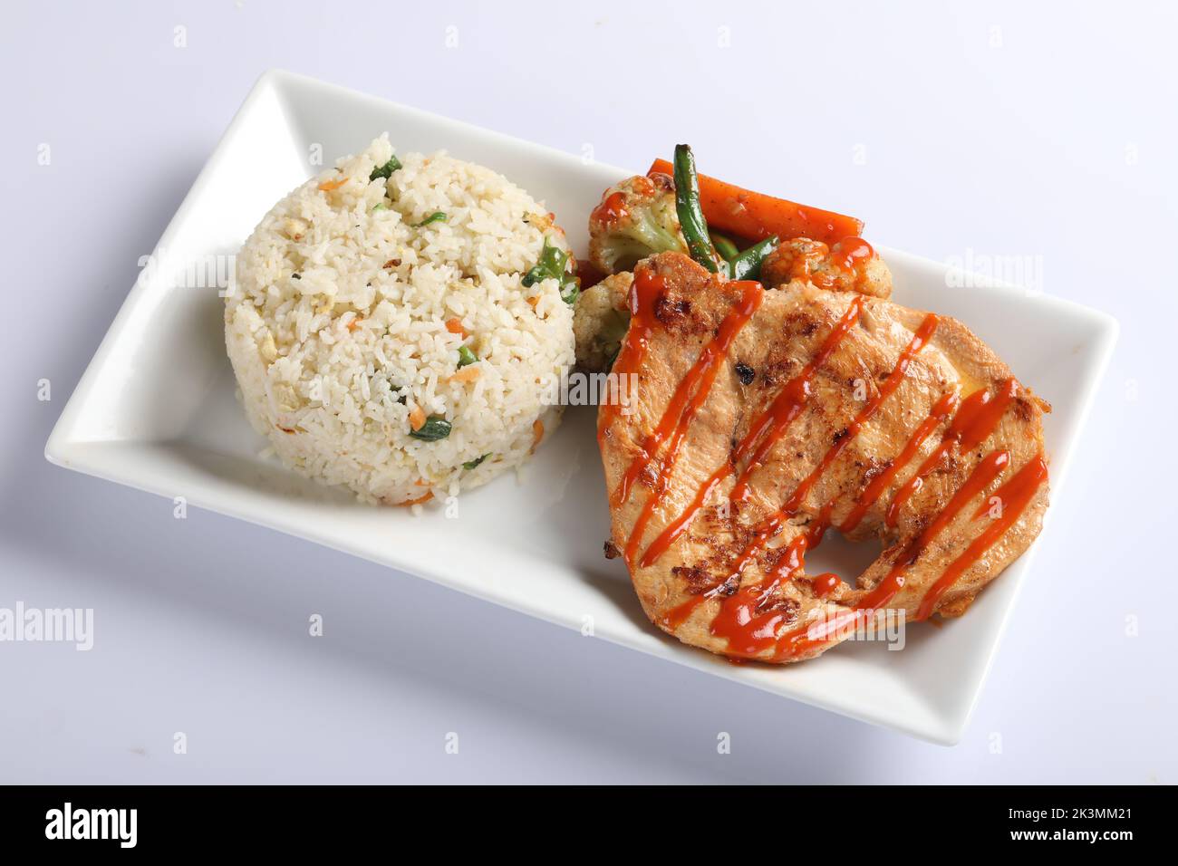 Riso fritto al pollo Schezwan in ciotola bianca isolata su fondo bianco. Il riso Szechuan è un piatto di cucina indo-cinese con peperoni, fagiolini, auto Foto Stock