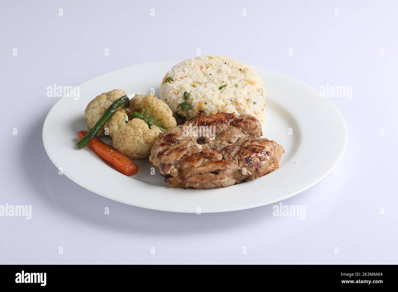 Riso fritto al pollo Schezwan in ciotola bianca isolata su fondo bianco. Il riso Szechuan è un piatto di cucina indo-cinese con peperoni, fagiolini, auto Foto Stock