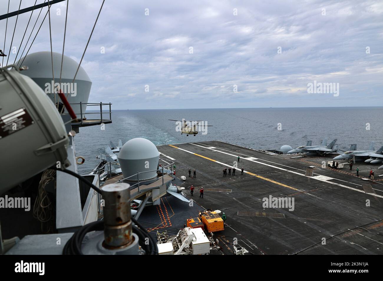 Soldiers from B Company, 3-2 General Support Aviation Battalion, 2nd Combat Aviation Brigade condusse atterraggi con elicotteri CH-47F Chinook sull'unico portaerei della Marina statunitense, USS Ronald Reagan (CVN 76), nel Mare Orientale il 26 settembre 2022. Le qualifiche di atterraggio sul ponte sono condotte per certificare i membri dell'equipaggio e i piloti che atterrano su una nave. Questo corso di formazione è stato condotto in parte con l'esercizio MCSOFEX (Maritime Counter Special Operations Exercise) per rafforzare l'interoperabilità con i nostri partner congiunti. Foto Stock