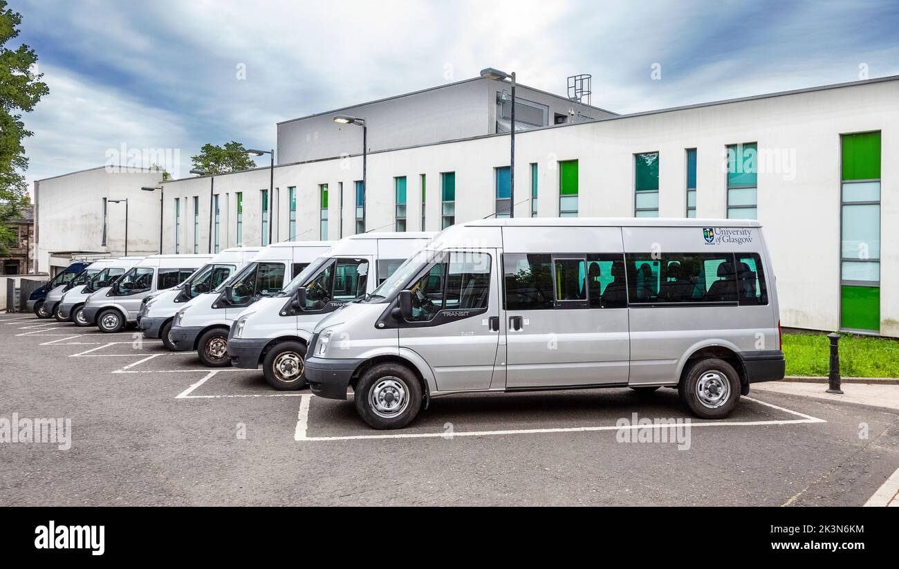 Una fila di minibus Ford Transit dell'Università di Glasgow parcheggiati fuori dalla Biblioteca Universitaria. Glasgow, Scozia, Regno Unito. Foto Stock