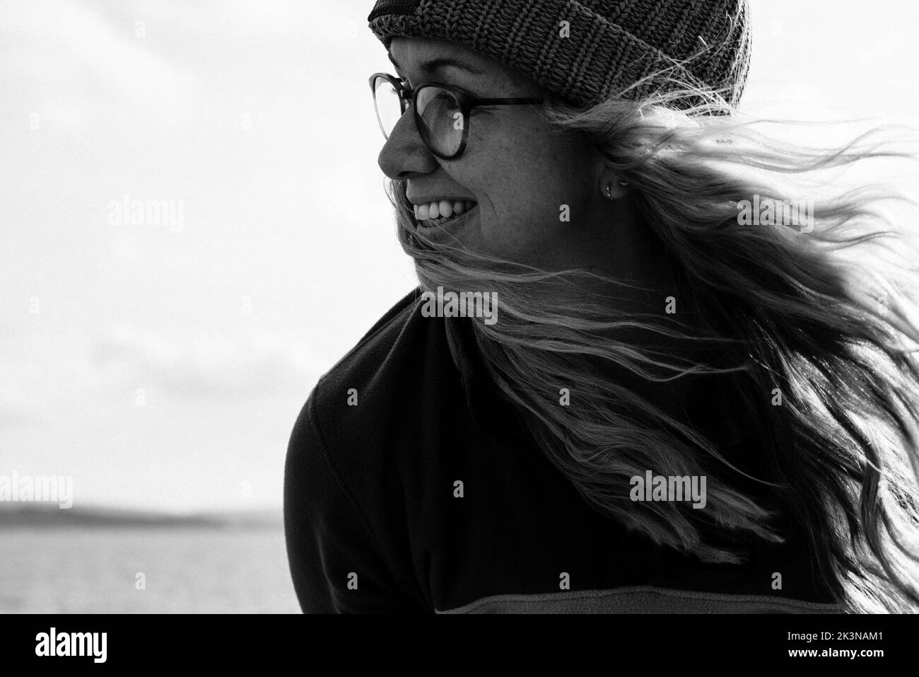 ritratto di donna sorridente con i capelli che soffiano nel vento Foto Stock