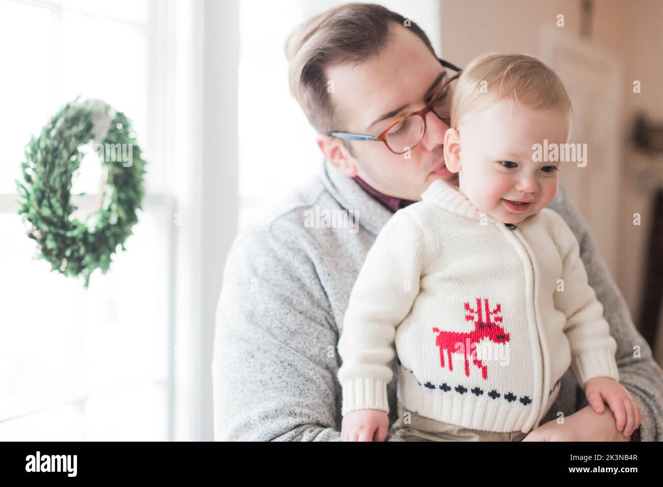 il padre di 30-35 anni gli tiene il figlio di 1-2 anni a natale. Foto Stock
