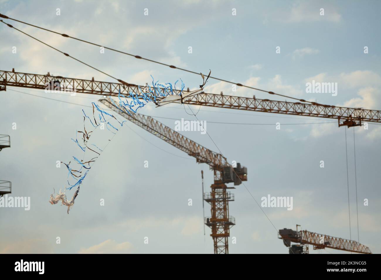 Un aquilone volante nel cielo con lo sfondo di una gru da cantiere Foto Stock