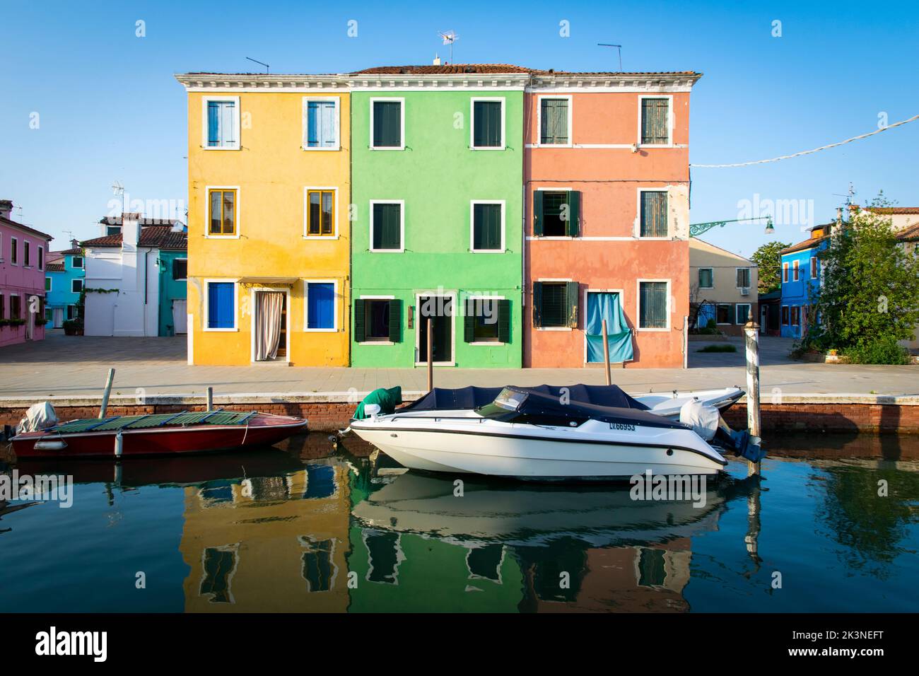 Tre case colorate e una barca nell'isola di Burano, Venezia Foto Stock
