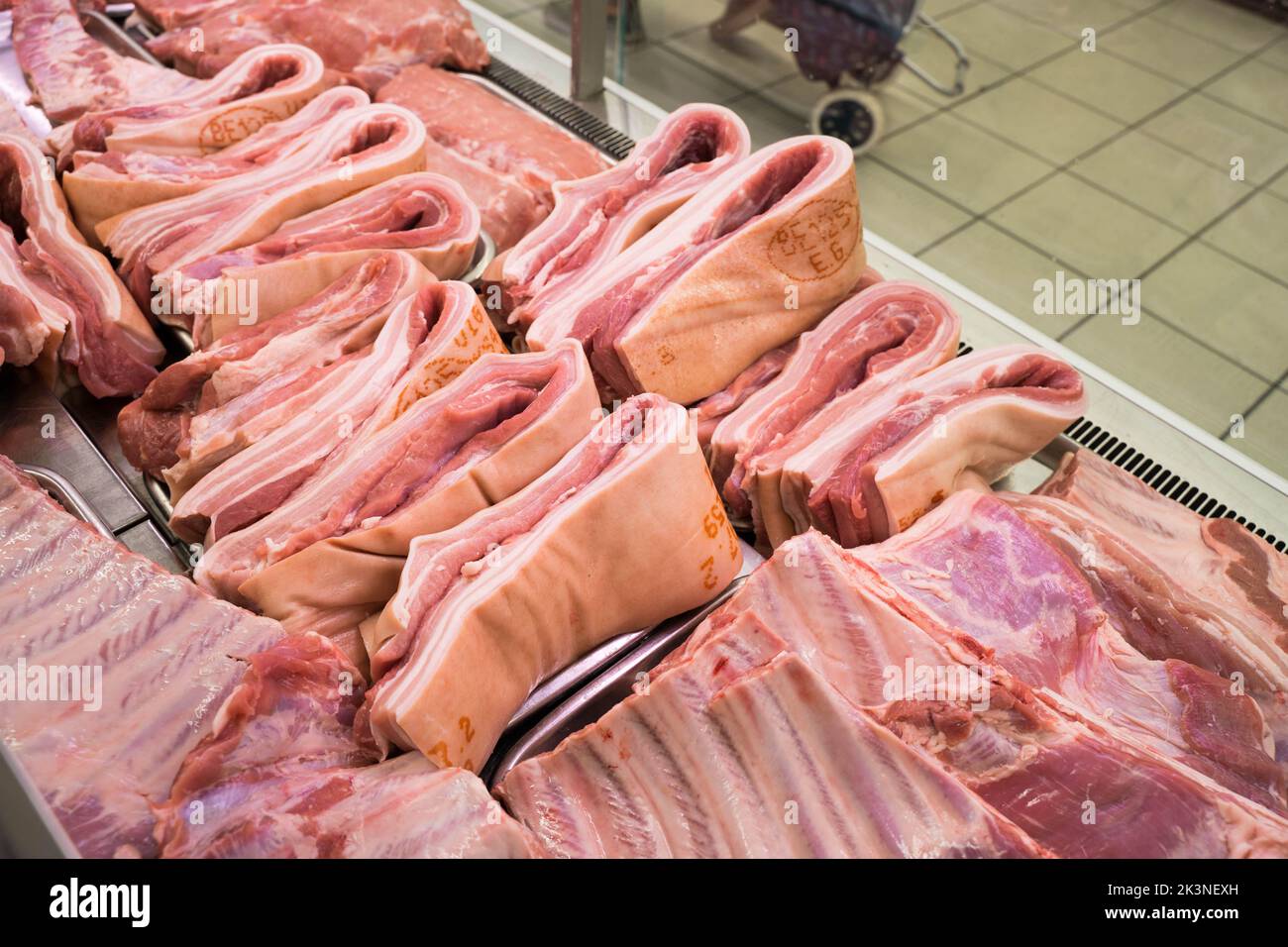 Strisce di pancie di maiale tagliate in misura pronta per la vendita in un macellaio Londra Inghilterra UK Foto Stock