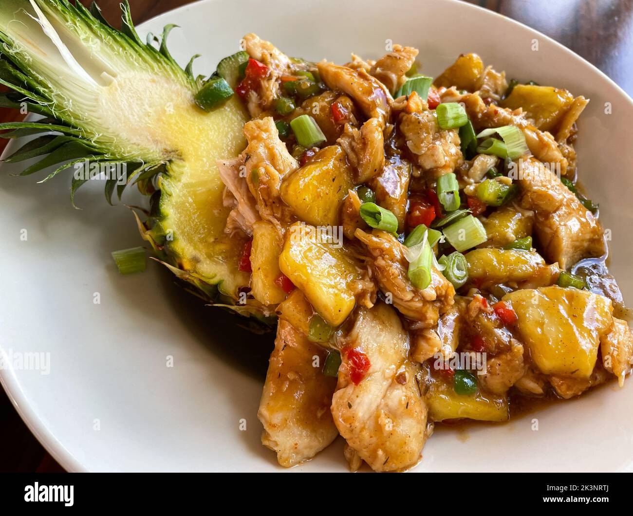 Chiudi il bicchierino di ananas di pollo con un bicchierino di ananas appena tagliato Foto Stock
