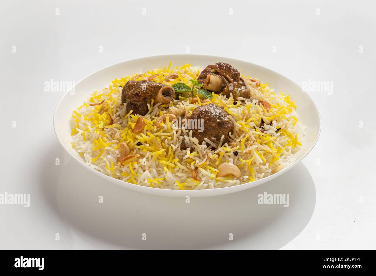 Dhum biriyani con riso jeera e spezie disposti in terrecotte con insalata su sfondo bianco. Foto Stock