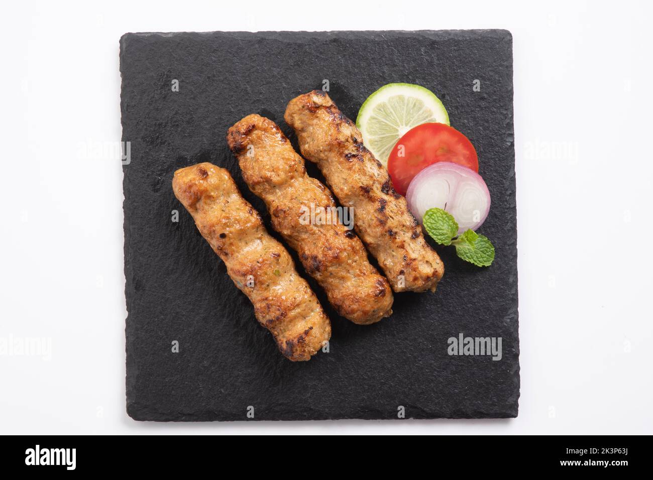 Seekh Kabab preparato con pollo tritato o cheema di Mutton, servito con chutney verde e insalata Foto Stock