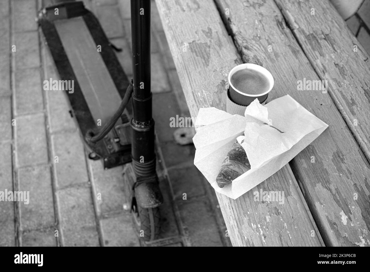outtdor in bianco e nero ha sparato un croissant, un caffè e uno scooter Foto Stock