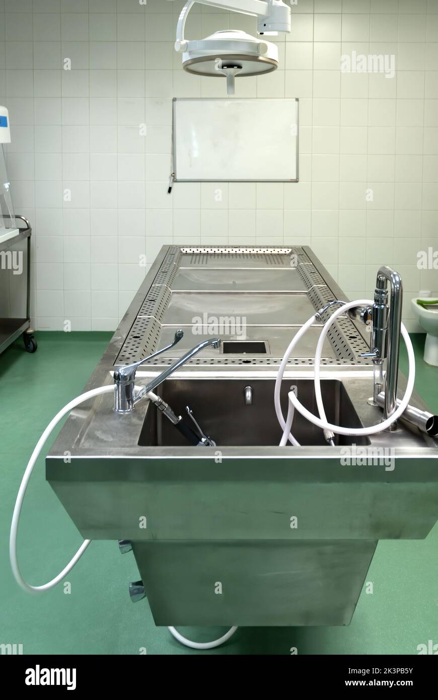 Un tavolo operatorio in acciaio inox utilizzato per eseguire lavori di dissezione in autopsia Foto Stock