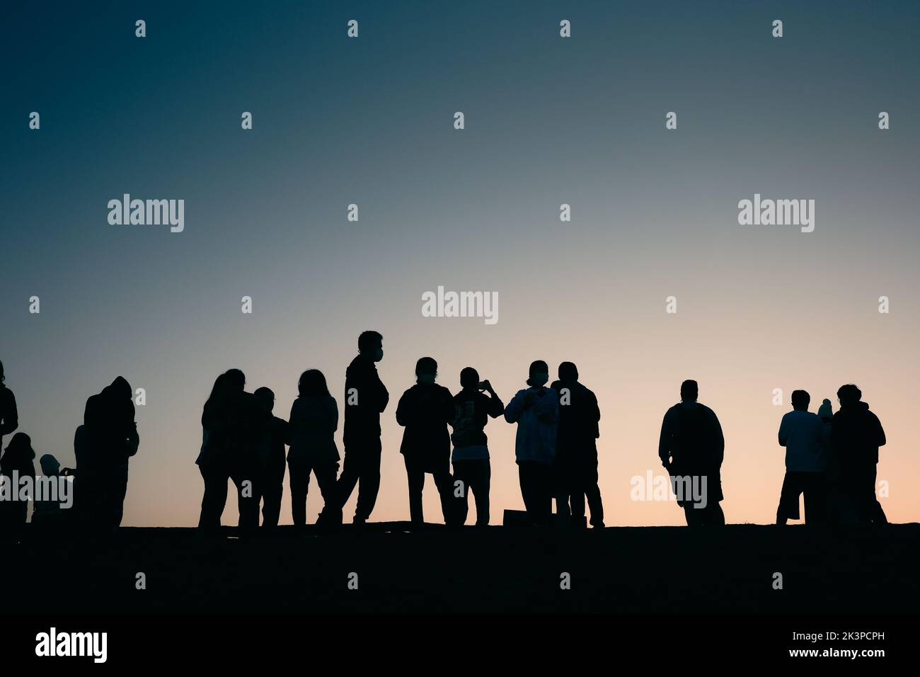 Nan, Thailandia - 15 dicembre 2021: Persone con silhouette in piedi sul bordo della cresta di montagna in attesa di vedere l'alba con cielo blu chiaro. Foto Stock