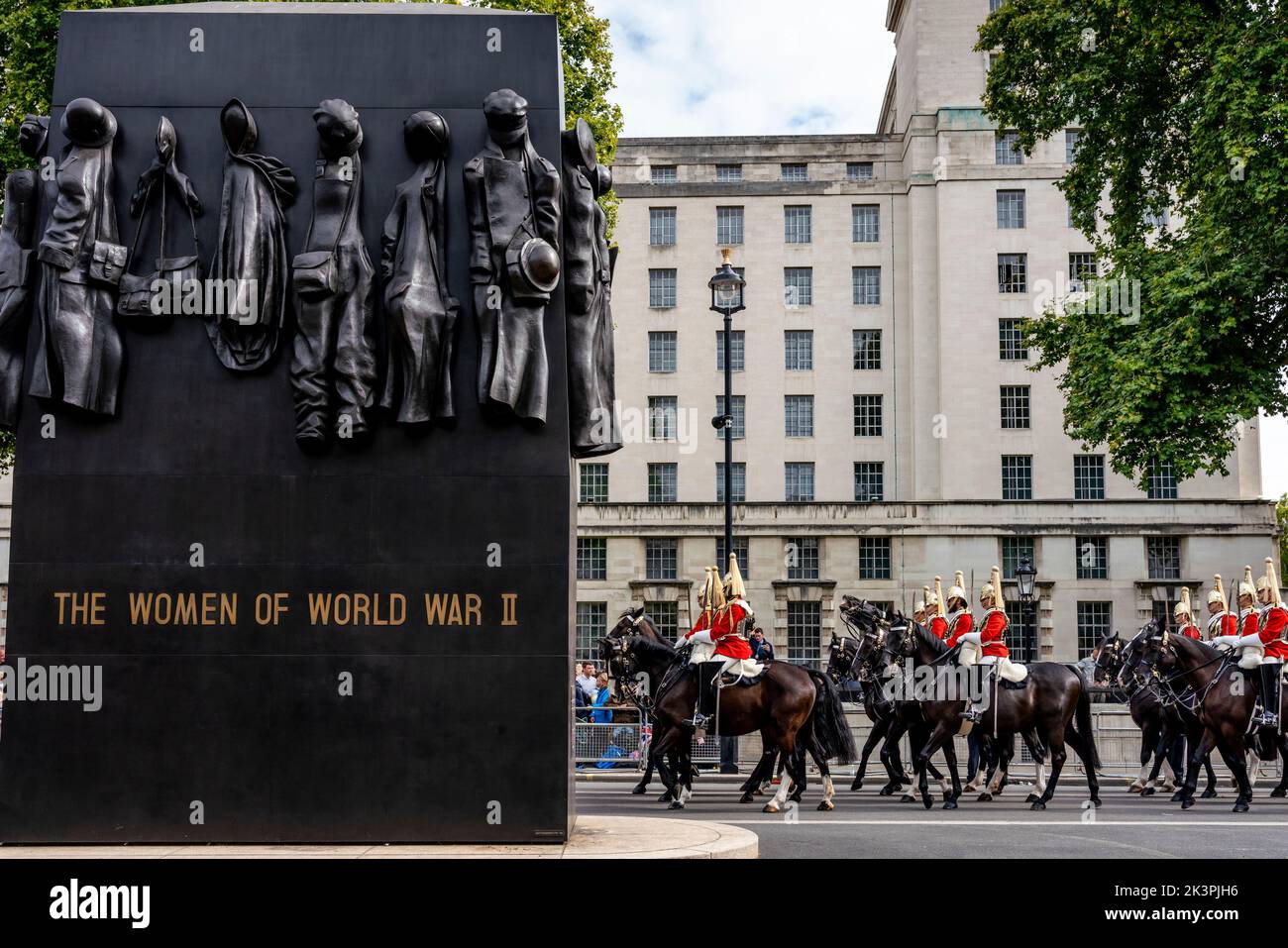 Le guardie della vita passano il Monumento delle Donne della Guerra Mondiale 2 mentre prendono parte alla processione funeraria della Regina Elisabetta II, Whitehall, Londra, Regno Unito. Foto Stock