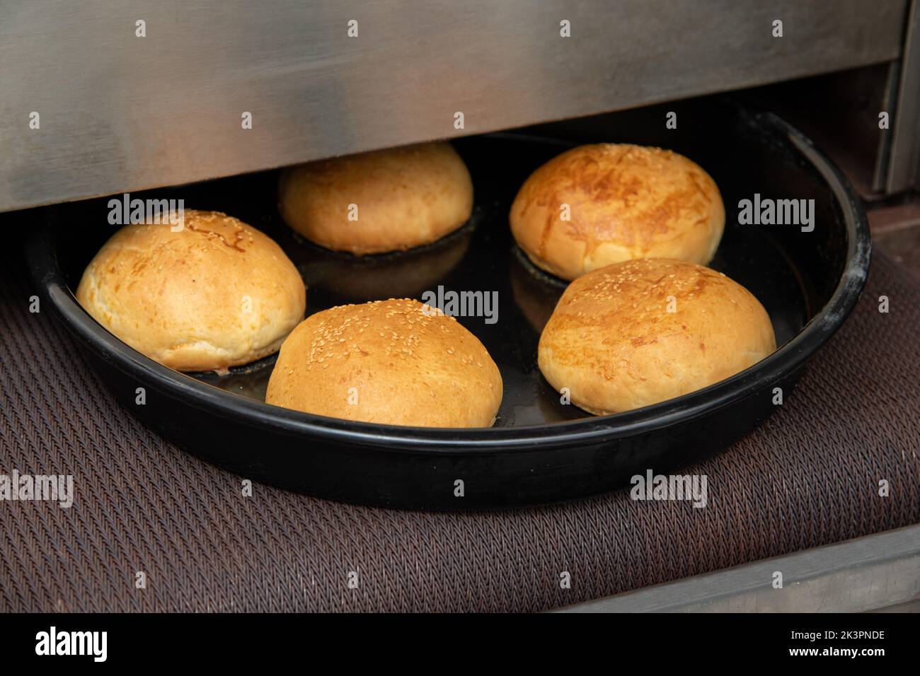 Hamburger panini caldi appena sfornati in un forno industriale Foto Stock