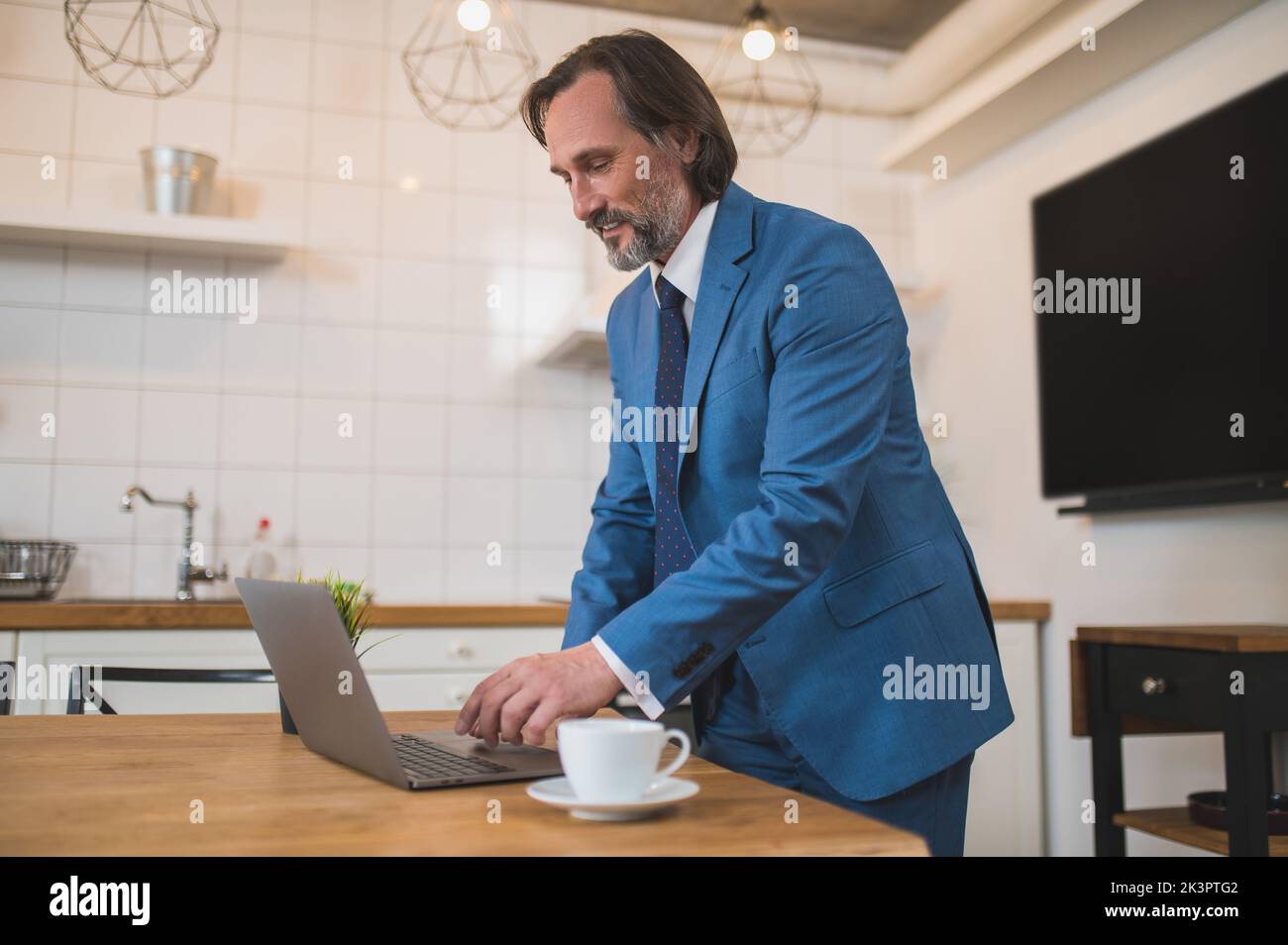 Uomo con elegante tuta blu pronto per la presentazione online Foto Stock
