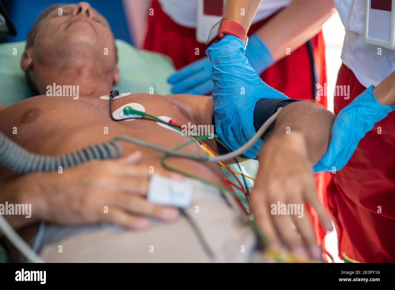 Personale paramedico che controlla i segni vitali di un malato Foto Stock