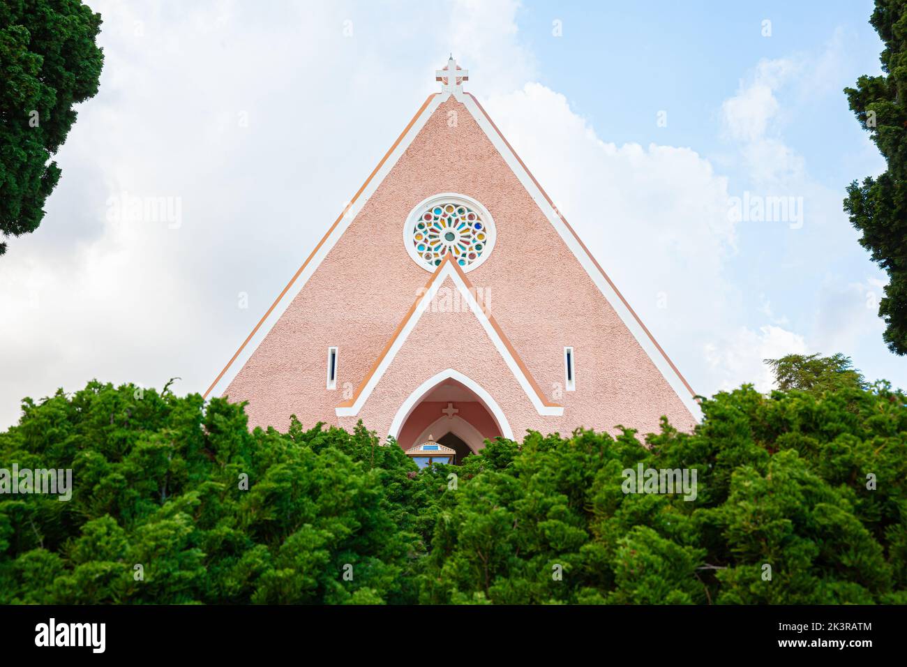Tetto di tegole della chiesa e croce crocifisso isolato su sfondo blu cielo a da Lat, Lam Dong, Vietnam Foto Stock
