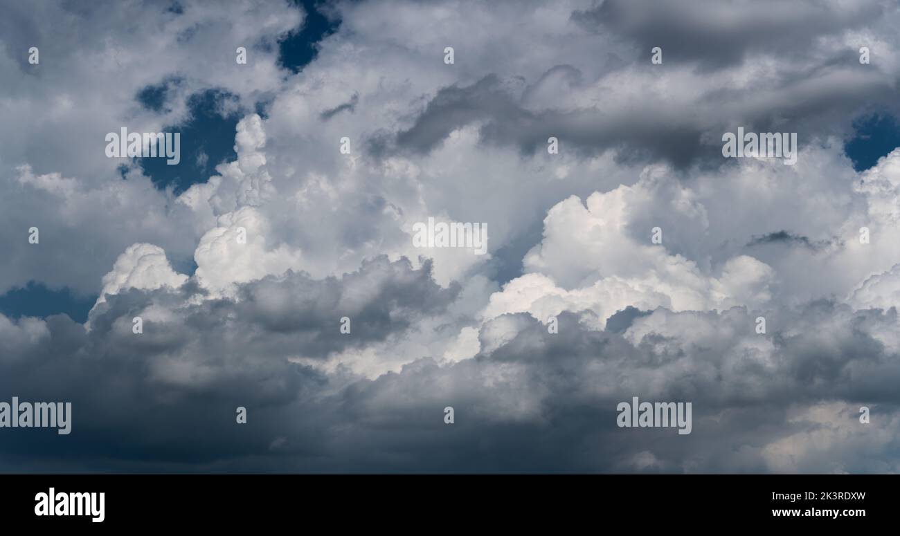 Grandi nuvole luminose contro il cielo blu scuro, nuvola in luce drammatica, vista panoramica Foto Stock