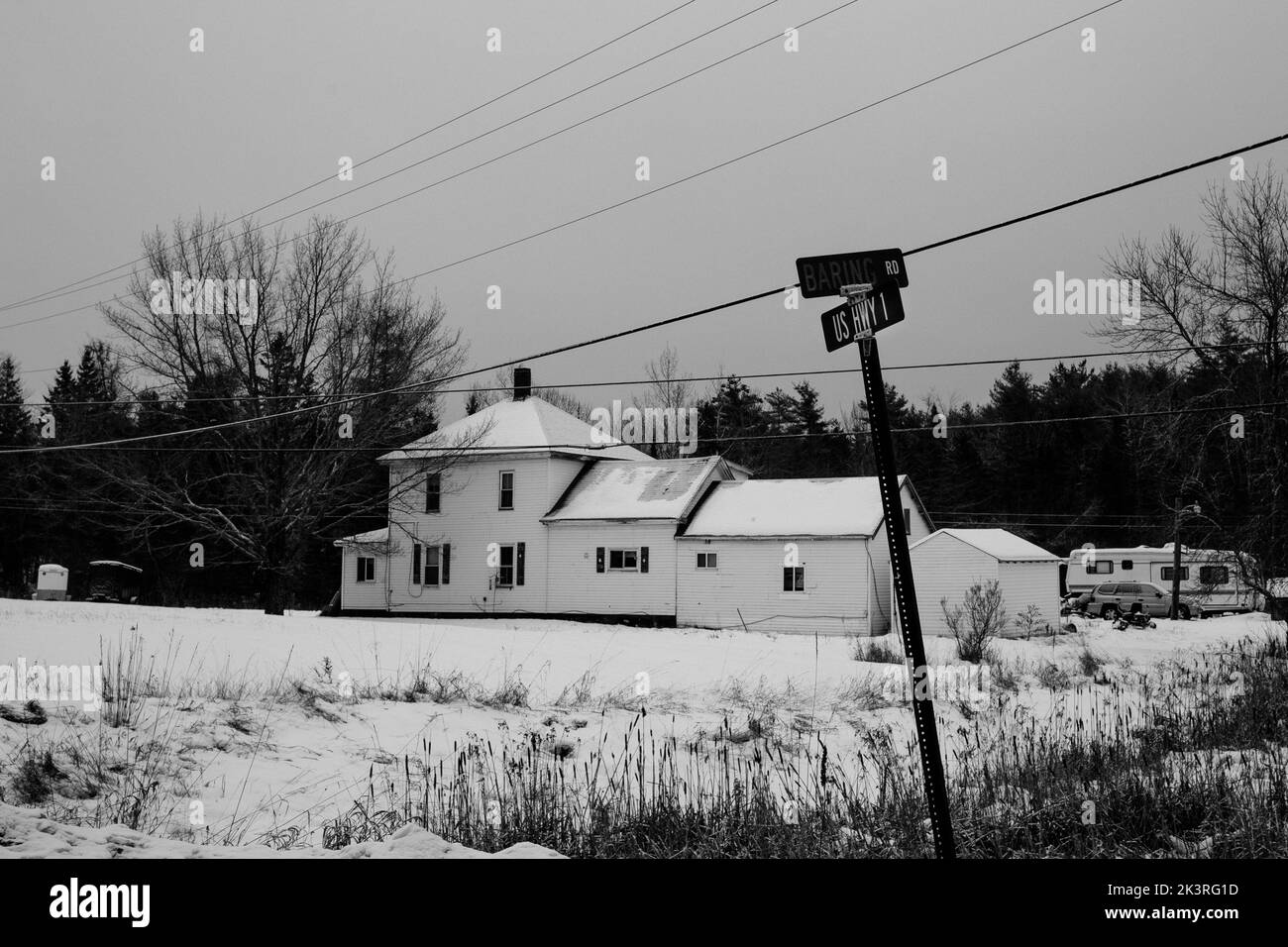 Uno scatto in scala di grigi di una casa coperta di neve vicino all'autostrada 1 in inverno nel Maine, Stati Uniti Foto Stock