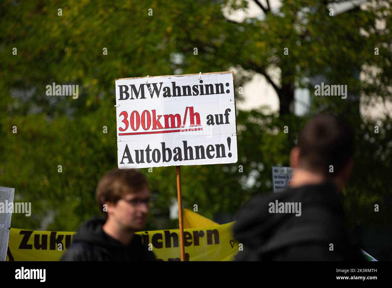 Teilnehmer*in mit Schild 'BMW Wahnsinn 300km/h auf Autobahnen'. Am 23.9.2022 versammelten sich in München bis zu 10,000 Menschen, um gemeinsam mit Fridays for Future auf dem Globalen Klimastreik für Klimagerechtigkeit, den Ausbau der dezentralen erneuerbaren Energien, kostengünstigen ÖPNV und für ein 100 MRD. Euro Sondervermögen für gerechte Klimaschutzmaßnahmen und Krisenprävention zu demonstrieren. Das motto des Großstreiks wieder guerra persone non profit. -- Partecipante con segno 'BMW follia 300km/h sulle autostrade'. Il 23 settembre 2022, fino a 10.000 persone si sono radunate a Monaco, in Germania, per protare Foto Stock