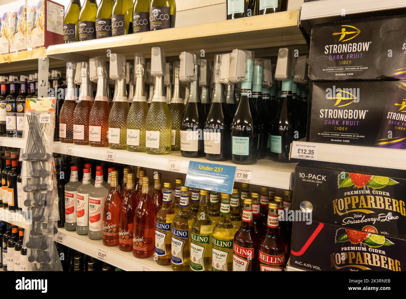 Bottiglie di vino e di alcool su uno scaffale in un supermercato con etichette di sicurezza su ogni bottiglia per fermare il sollevamento del negozio nel Regno Unito Foto Stock