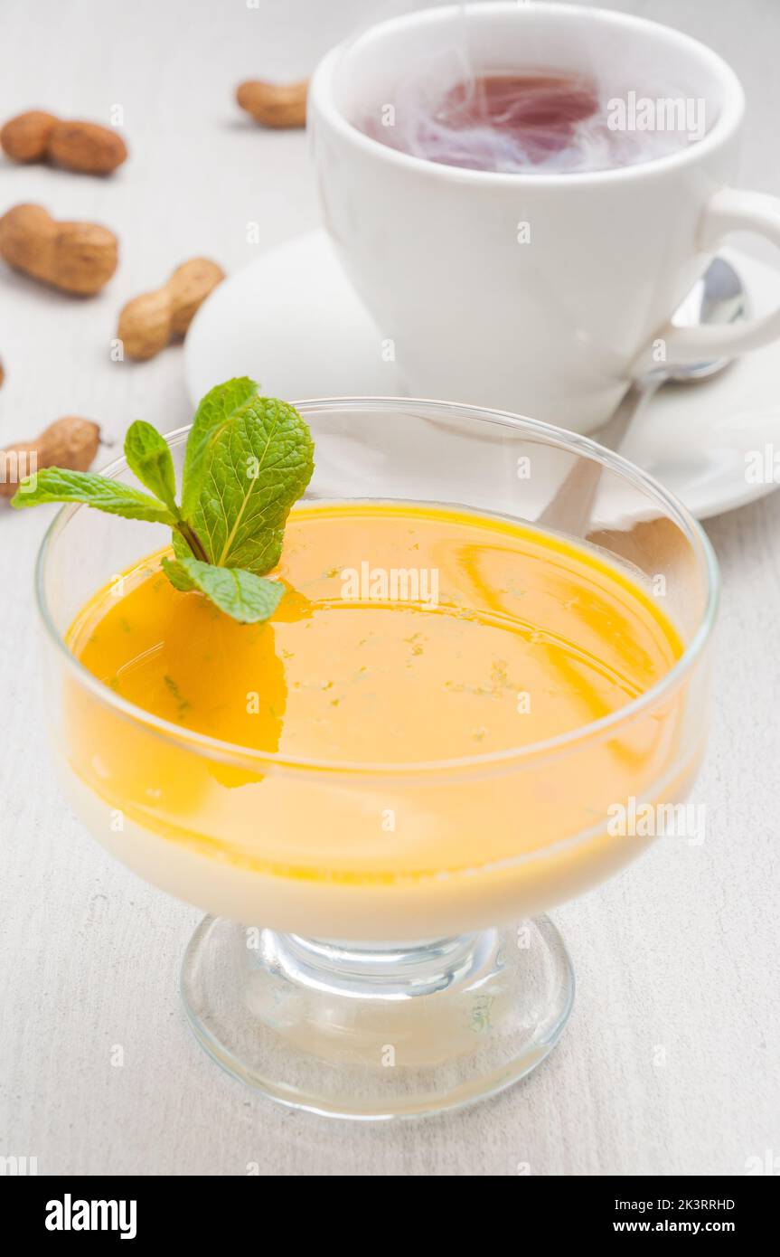 Gustoso dessert di Pana cotta con mango e tè caldo Foto Stock