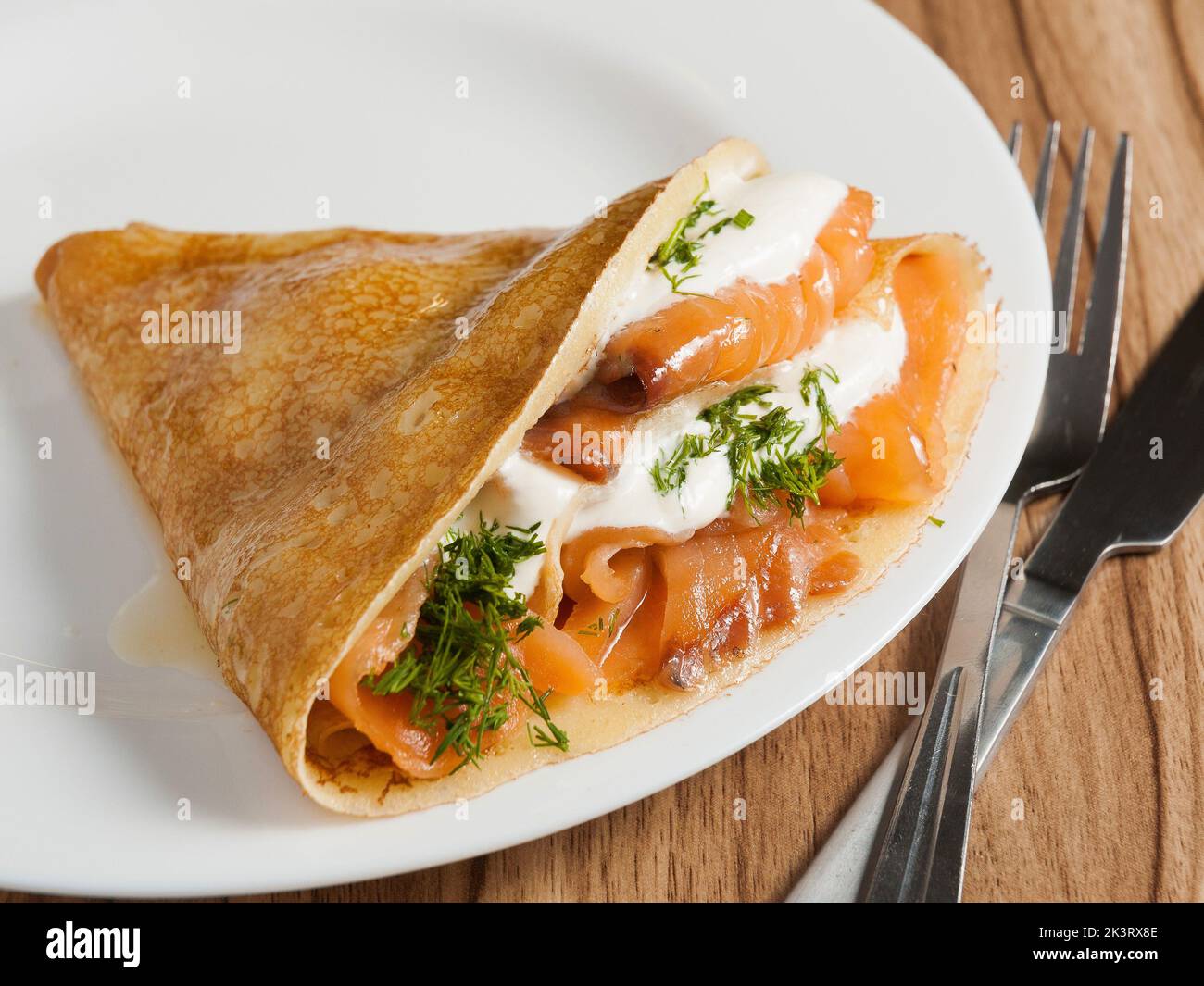 gustosa frittella con salmone e formaggio cremoso su un piatto bianco Foto Stock