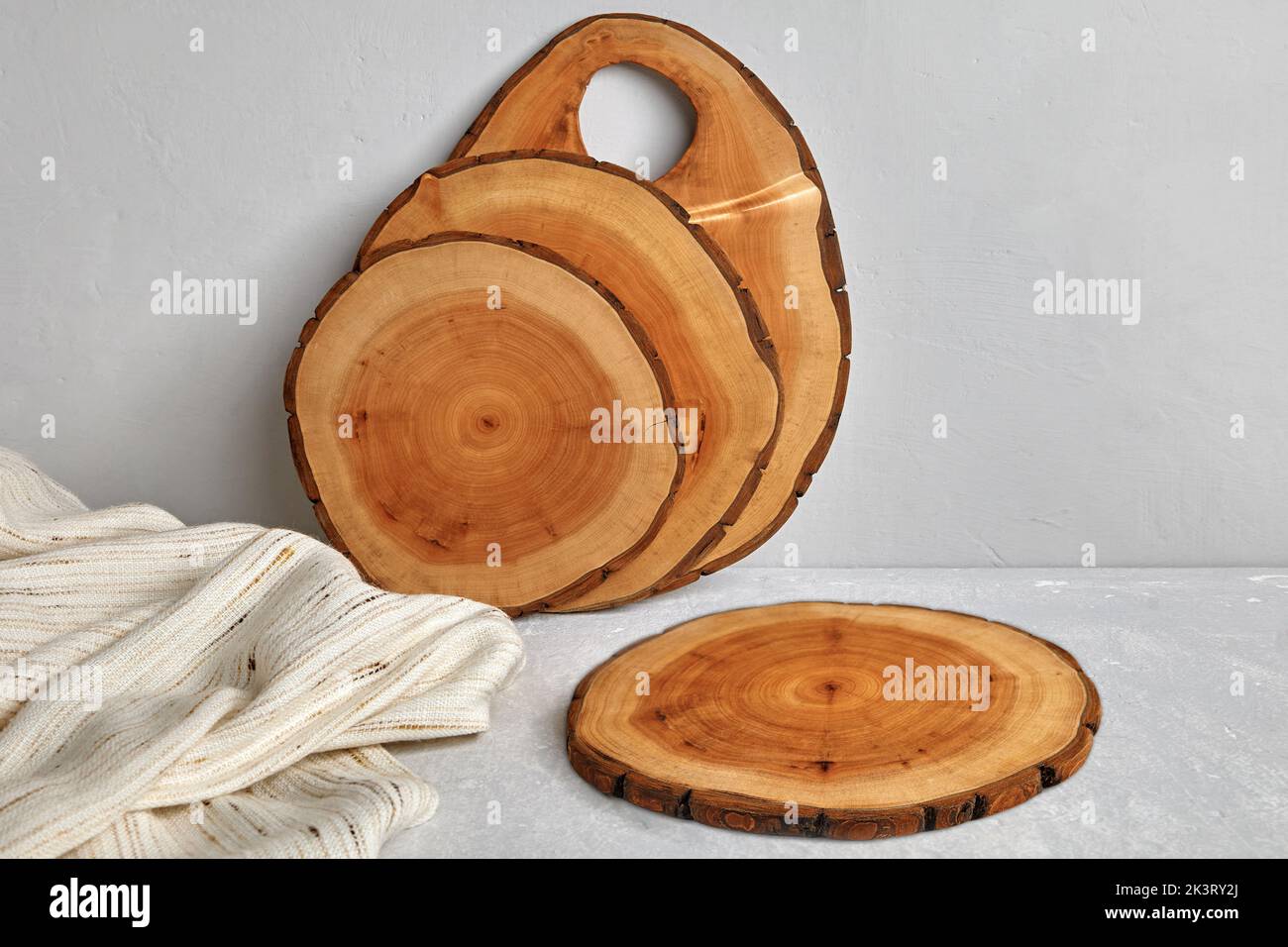 Angolo cottura con asse da taglio in legno e tovagliolo da tè su un tavolo di cemento chiaro per la presentazione dei cibi Foto Stock