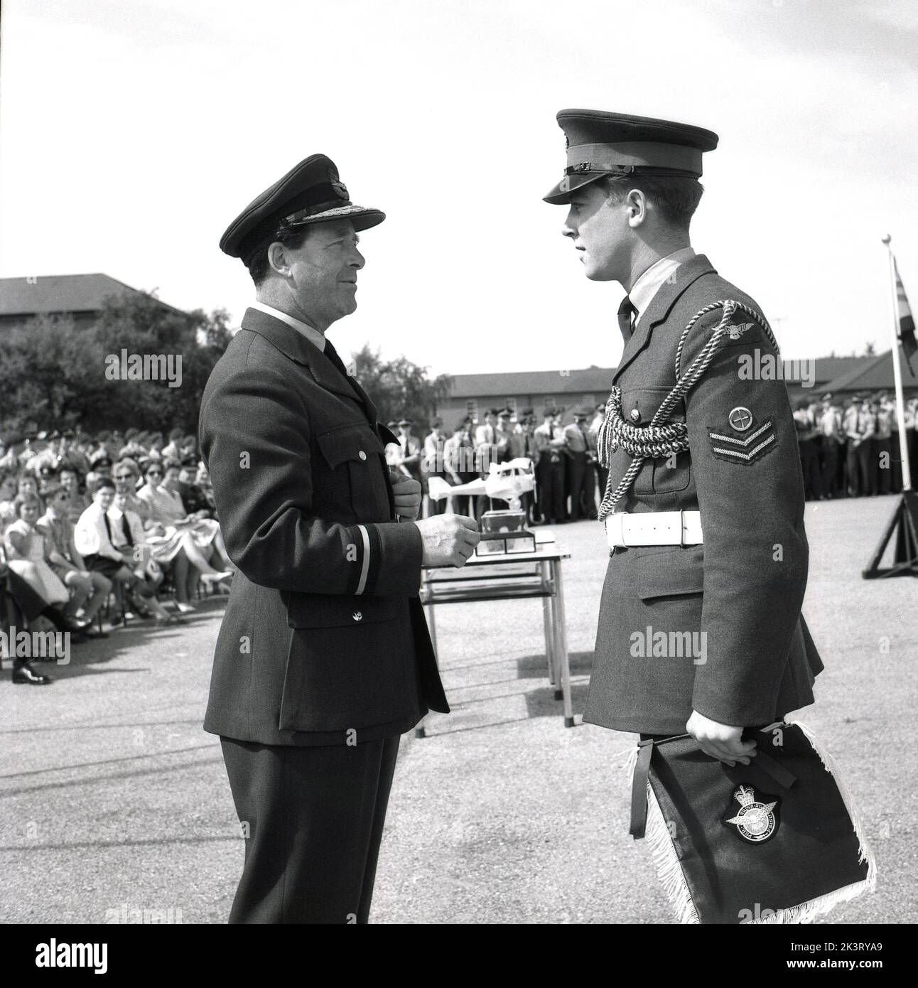 1964, storico, una cerimonia di presentazione alla RAF Halton, Bucks, Inghilterra, Regno Unito, un ufficiale che assegna ali a un nuovo laureato. La RAF Halton fu la sede della No 1 School of Technical Training, la scuola di ingegneria aeronautica della Royal Air Force dal 1919 al 1993. prendere le loro ali???? Per Ardvarl Astra? Foto Stock