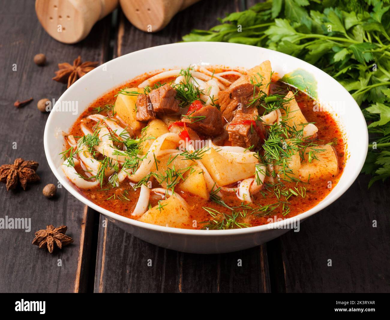 gustoso lagman con manzo in un piatto bianco su fondo di legno Foto Stock