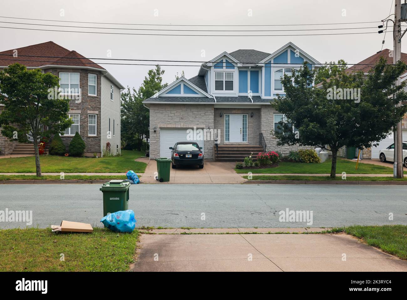 Segregazione rifiuti - riciclare sacchetti blu, scatole di cartone ondulato e carrello rifiuti organici verdi tenuti all'esterno. HALIFAX, NOVA SCOTIA, CANADA - LUGLIO 2022 Foto Stock