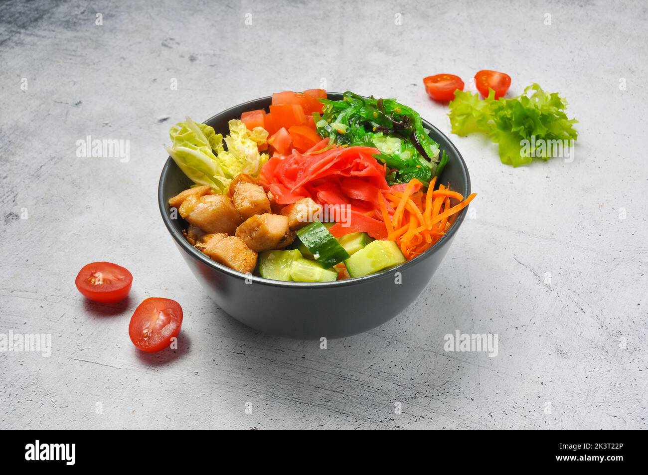 gustosa poke con pollo e verdure in un piatto profondo su sfondo chiaro Foto Stock