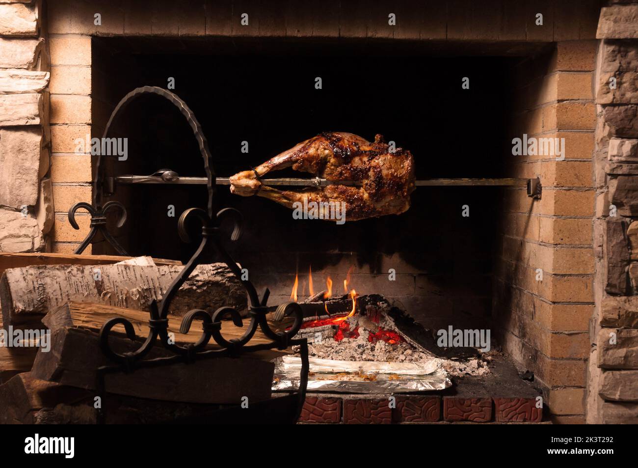 gustoso dorso di agnello su una sputata con un bicchiere di brandy Foto Stock