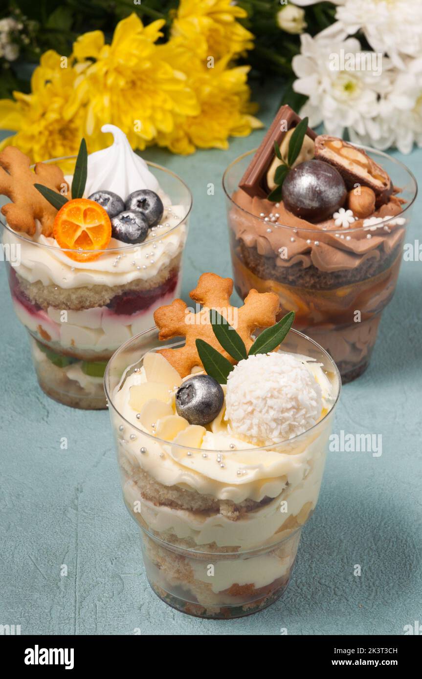 dolci dolci in tazze di plastica con crema e cioccolato Foto Stock